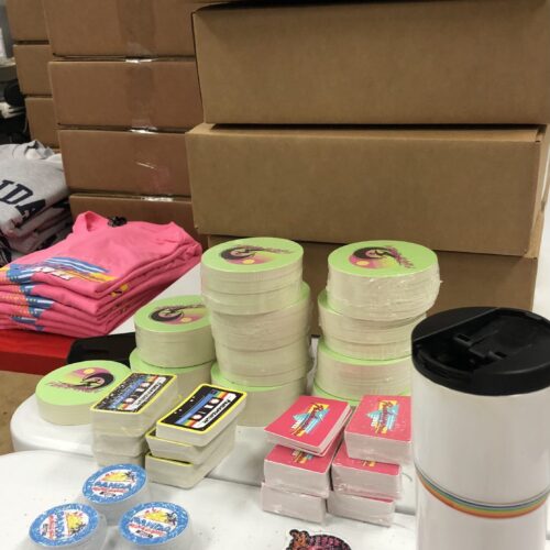 A table with stacks of colorful printed swag