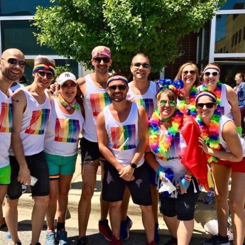 People wearing rainbow printed tees